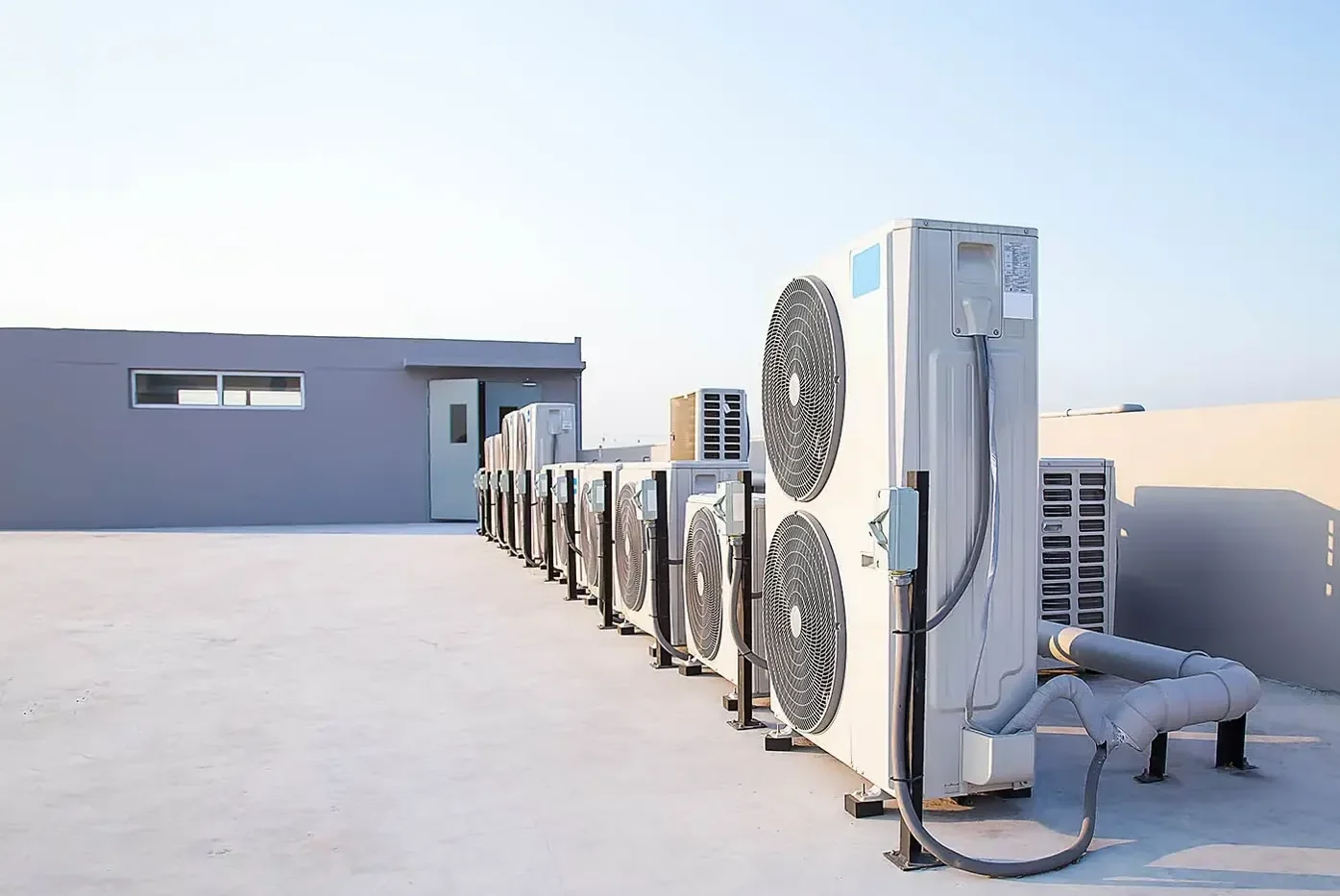Row of air conditioning condensers on a commercial rooftop